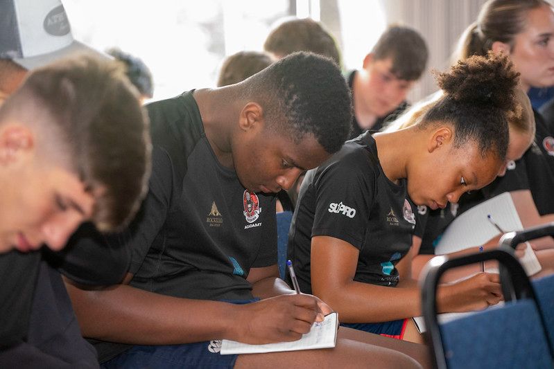 Close-up of players writing in notebooks